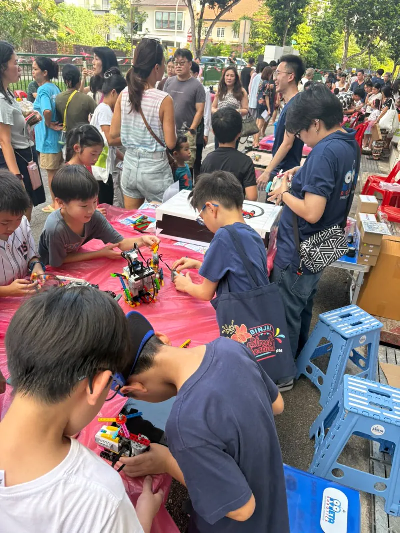 Children building robots at the Meta Robotics booth during the Binjai Street Festival