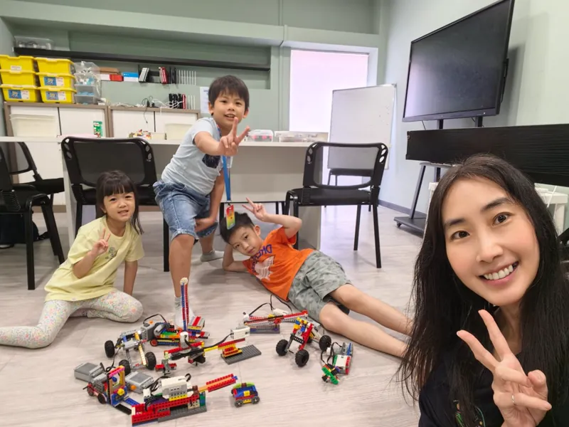 Children and their teacher posing with the robots they built during a Meta Robotics holiday workshop